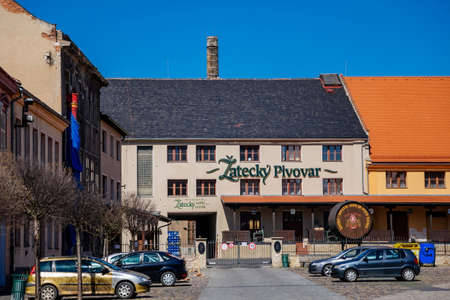 Zatecky pivovar, Zatecky Brewery, Ancient building with stone chimney, sunny day, Beer cask with slogan: Zatec town, where beer is home, brewery village Zatec, Bohemia, Czech Republic, April 04, 2021のeditorial素材