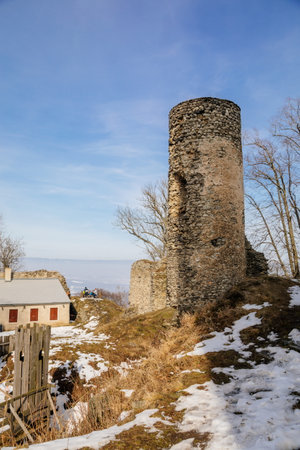 Medieval gothic castle Kostomlaty or Sukoslav, gray stone ruin on hill at sunny winter day, ancient fortress under snow, fairytale stronghold, round guard tower, Czech Republic, February 20, 2021のeditorial素材
