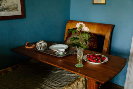 Velke Brezno, Czech Republic, 26 June 2021: chateau Velke Brezno, castle interior of blue bedroom, bed with a bedside table set for breakfast, a vase of pink roses and a plate of strawberries.のeditorial素材