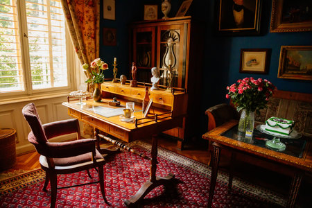 Velke Brezno, Czech Republic, 26 June 2021: chateau Velke Brezno, castle interior with baroque furniture, cabinet with wooden writing desk, armchair on carpet near windows, figurines and documents.のeditorial素材