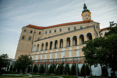 Mikulov, South Moravian Region, Czech Republic, 05 July 2021: Baroque castle or chateau with tower on top of rock surrounded by gardens at sunny summer evening, medieval building in center of town.のeditorial素材