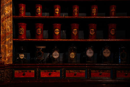 Kuks, East Bohemia, Czech Republic, 10 July 2021: Baroque hospital Kuks, interior of historic pharmacy, Vintage glass bottles on wooden table and shelf, medical background, Museum antique drugstore.のeditorial素材