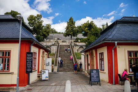 Kuks, East Bohemia, Czech Republic, 10 July 2021: well or a fountain with statues of Triton Greek god of sea, staircase with water cascade at sunny summer day, baroque castle and hospital Kuks.のeditorial素材