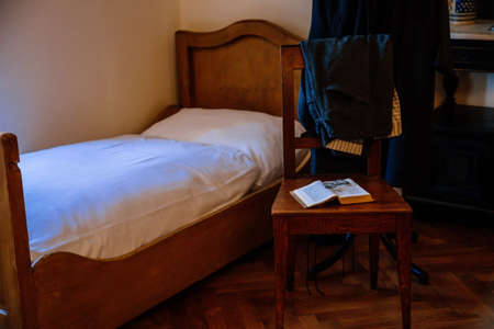 Kuks, East Bohemia, Czech Republic, 10 July 2021: Baroque castle and hospital Kuks, historic interior of old museum, patient room, wooden bed, table and chairs, Vintage medical background.のeditorial素材