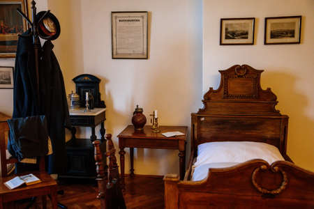 Kuks, East Bohemia, Czech Republic, 10 July 2021: Baroque castle and hospital Kuks, historic interior of old museum, patient room, wooden bed, table and chairs, Vintage medical background.のeditorial素材