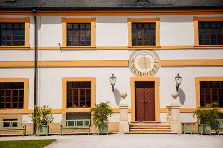 Kuks, East Bohemia, Czech Republic, 10 July 2021: Baroque castle and hospital Kuks, courtyard with antique sundial on the facade, Beautiful complex with chateau and Holy Trinity Church at summer dayのeditorial素材