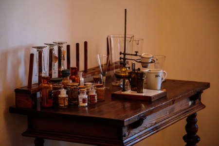 Kuks, East Bohemia, Czech Republic, 10 July 2021: Baroque hospital Kuks, interior of historic pharmacy, Vintage glass bottles on wooden table and shelf, medical background, Museum antique drugstore.のeditorial素材