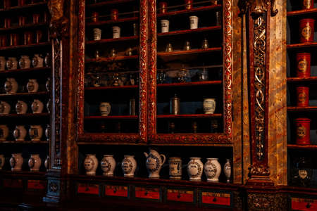 Kuks, East Bohemia, Czech Republic, 10 July 2021: Baroque hospital Kuks, interior of historic pharmacy, Vintage glass bottles on wooden table and shelf, medical background, Museum antique drugstore.のeditorial素材