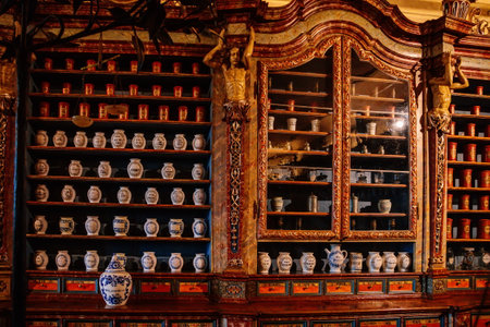 Kuks, East Bohemia, Czech Republic, 10 July 2021: Baroque hospital Kuks, interior of historic pharmacy, Vintage glass bottles on wooden table and shelf, medical background, Museum antique drugstore.のeditorial素材