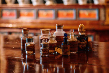 Kuks, East Bohemia, Czech Republic, 10 July 2021: Baroque hospital Kuks, interior of historic pharmacy, Vintage glass bottles on wooden table and shelf, medical background, Museum antique drugstore.のeditorial素材