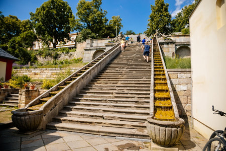 Kuks, East Bohemia, Czech Republic, 10 July 2021: well or a fountain with statues of Triton Greek god of sea, staircase with water cascade at sunny summer day, baroque castle and hospital Kuksのeditorial素材