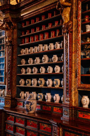 Kuks, East Bohemia, Czech Republic, 10 July 2021: Baroque hospital Kuks, interior of historic pharmacy, Vintage glass bottles on wooden table and shelf, medical background, Museum antique drugstore.のeditorial素材