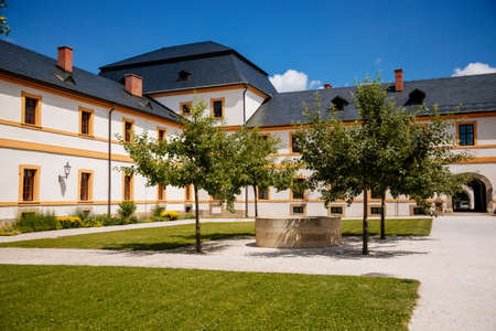 Kuks, East Bohemia, Czech Republic, 10 July 2021: Baroque castle and hospital Kuks, courtyard with garden and antique facade, Beautiful complex with chateau, Holy Trinity Church at sunny summer dayのeditorial素材