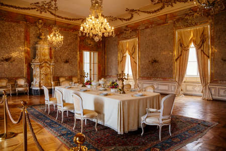 Valtice, Southern Moravia, Czech Republic, 04 July 2021: castle interior with baroque furniture, dining room with marble walls, large dining table next to white ceramic tiled stove, beautiful chateau.のeditorial素材