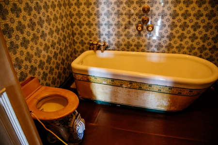 Valtice, Southern Moravia, Czech Republic, 04 July 2021: Castle interior with baroque wooden carved furniture, antique bathroom with large ceramic bathtub and toilet, painted tiles, romantic chateau.のeditorial素材