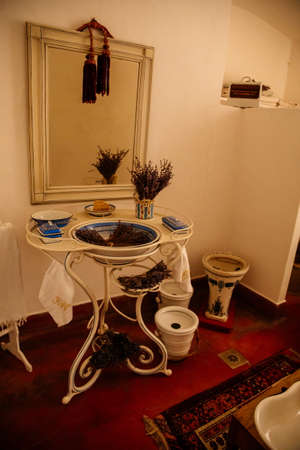Jaromerice nad Rokytnou, Bohemia, Czech Republic, 06 July 2021: Castle interior with baroque wooden carved furniture, bathroom, white and blue porcelain sink with mirror and dried lavender bouquets.のeditorial素材