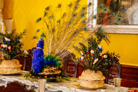 Jaromerice nad Rokytnou, Czech Republic, 06 July 2021: Castle interior with baroque wooden carved furniture, dining room with set table, peacock feather cake, white ceramic tiled stove.のeditorial素材