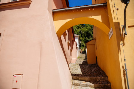 Trebic, Bohemia, Czech Republic, 06 July 2021: Narrow picturesque street with colorful buildings in historic center in medieval city, renaissance and baroque historical buildings at summer sunny day.のeditorial素材