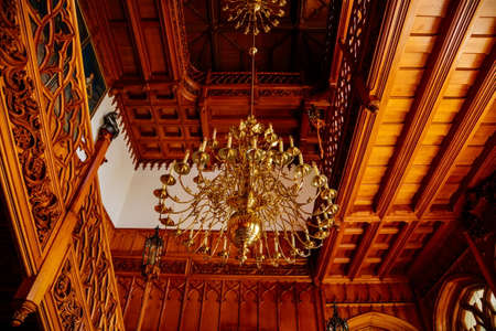 Lednice, Southern Moravia, Czech Republic, 04 July 2021: Castle interior with neo-gothic wooden carved furniture, Decorative staircase at hall, floral ornaments, chandelier candelabrum with candles.のeditorial素材