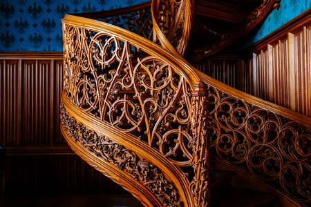 Lednice, Southern Moravia, Czech Republic, 04 July 2021: Castle interior with neo-gothic romantic wooden carved furniture, Decorative spiral staircase with floral ornaments at blue chateau library.のeditorial素材