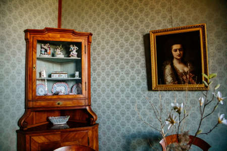 Lednice, Southern Moravia, Czech Republic, 04 July 2021: Castle interior, oriental salon, wardrobe with Chinese porcelain, portrait of a woman on the wall, green wallpaper, beautiful UNESCO chateau.のeditorial素材