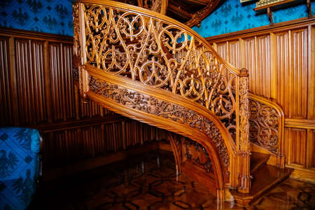 Lednice, Southern Moravia, Czech Republic, 04 July 2021: Castle interior with neo-gothic romantic wooden carved furniture, Decorative spiral staircase with floral ornaments at blue chateau library.のeditorial素材