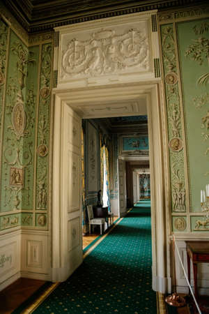 Vranov nad dyji, Southern Moravia, Czech Republic, 03 July 2021: Castle interior, baroque wooden carved furniture, green guest salon, painted walls with floral ornament, suite of rooms or enfilade.のeditorial素材