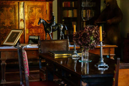 Cervena Lhota, South Bohemia, Czech Republic, 9 October 2021: Castle interior with baroque wooden carved furniture, study with writing desk, bronze statue of horseman, documents and portrait on tableのeditorial素材