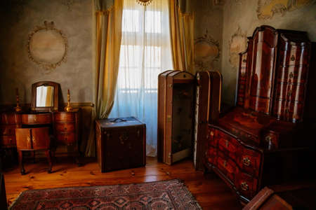 Cervena Lhota, South Bohemia, Czech Republic, 9 October 2021: Castle interior, baroque wooden carved furniture, dressing room, chest of drawers or ladies' table with mirror, antique suitcaseのeditorial素材
