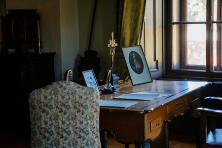 Cervena Lhota, South Bohemia, Czech Republic, 9 October 2021: Castle interior with baroque wooden carved furniture, study with writing desk, crucifix and icon depicting Jesus Christ on tableのeditorial素材