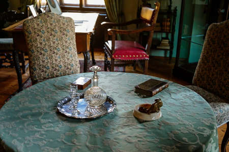 Cervena Lhota, South Bohemia, Czech Republic, 9 October 2021: Castle interior with baroque wooden carved furniture, table covered with embroidered tablecloth, decanter and crystal glassesのeditorial素材