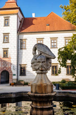 Trebon, South Bohemia, Czech Republic, 9 October 2021: Castle Courtyard, Renaissance chateau with sgraffito mural decorated plaster at facade, fountain with sculpture of bird perched on three heads.のeditorial素材