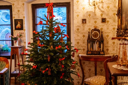 Kolin, Czech Republic, 26 December 2021: Regional Museum Town House Cervinkovsky dum, Interior with Biedermeier style furniture, Christmas tree and decorations, sofa armchairs near desk, living roomのeditorial素材