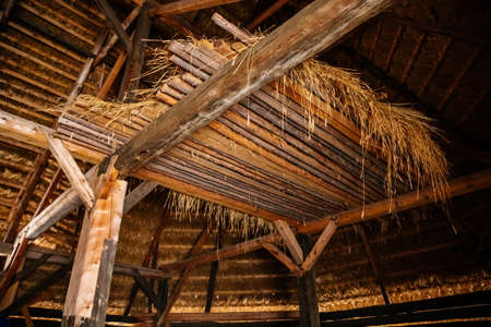 Kourim, Czech Republic, 26 December 2021: Inside rustic wooden old barn hay, Attic of hayloft, Bales dry straw, light beams farm, village rural lifestyle background, open-air ethnographic museumのeditorial素材