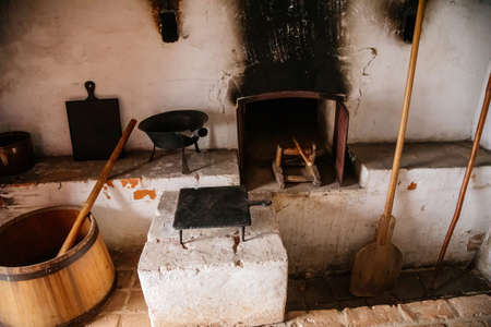 Kourim, Bohemia, Czech Republic, 26 December 2021: Interior of Traditional village house, country-style architecture, open-air ethnographic museum, Antique kitchen, rustic oven, pots and pansのeditorial素材