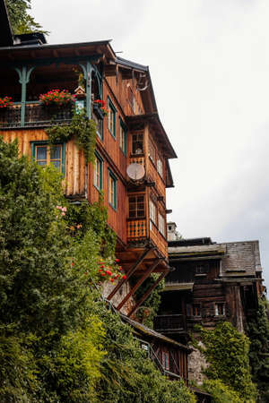 Hallstatt, Austria, 27 August 2021: Colorful scenic picturesque town street at summer day, mountain village near lake, Alps, UNESCO heritage, traditional wooden houses with balconies, flowers in potsのeditorial素材