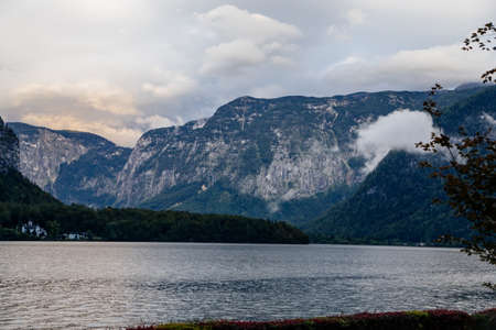 Hallstatt, Austria, 27 August 2021: Alps Mountain Krippenbrunn near alpine deep blue lake at summer day, coniferous forest on hillside, clouds and evening sky, Schloss Grub, Salzkammergutのeditorial素材