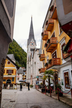 Hallstatt, Austria, 27 August 2021: Colorful scenic picturesque town street at summer day, mountain village near lake, Alps, Lutheran Church, UNESCO heritage, traditional historical houses, water lakeのeditorial素材