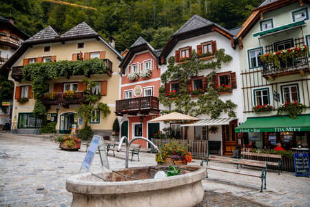 Hallstatt, Austria, 27 August 2021: Colorful scenic picturesque town street at summer day, mountain village near lake and Alps, UNESCO heritage, traditional houses, wooden balconies, flowers in potsのeditorial素材
