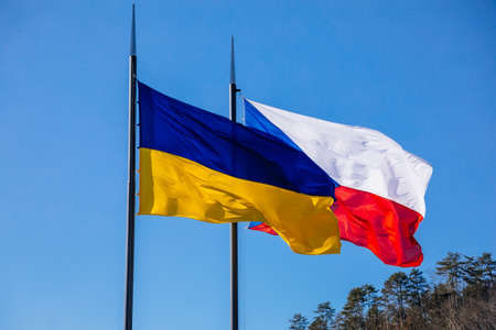 Karlstejn, Czech Republic, 12 March 2022: Flags of Ukraine and Czech Republic or Czechia on flagpoles flying on poles side by side. Independent free Ukraine. Solidarity with Ukraine people.のeditorial素材