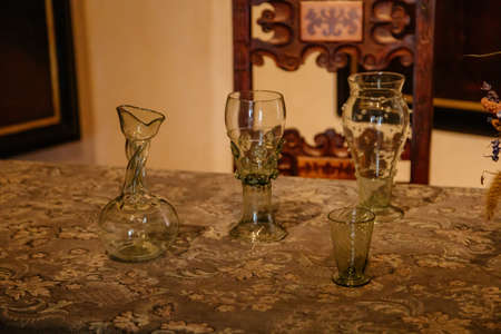 Karlstejn, Bohemia, Czech Republic, 12 March 2022: historical replica of forest medieval historical wine glass on table, medieval gothic castle interior, antique wood carved furniture, dining roomのeditorial素材