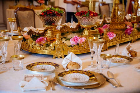 Lazne Kynzvart, Czech Republic, 7 August 2021: Metternich representative chateau or castle interiors, dining room with long table and gilded porcelain dishes, plates and glasses, golden candelabraのeditorial素材