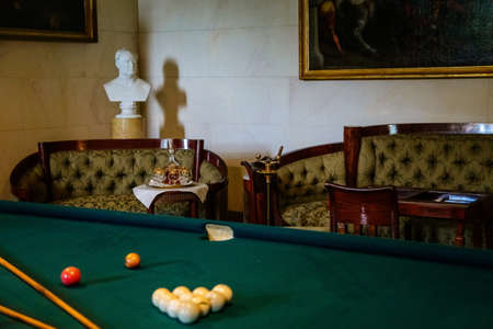 Lazne Kynzvart, Czech Republic, 7 August 2021: Metternich representative chateau or castle interior, salon carved wooden baroque and classic furniture with billiard table, white ceramic tiled stoveのeditorial素材