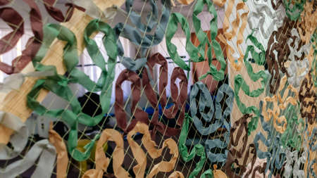 Kyiv, Ukraine, 7 April 2022: Civilian volunteers weave and knit camouflage nets for Ukrainian Military, sewing and craft cover camouflage for army troops, people woman and children mobilize to helpのeditorial素材