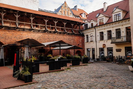 Riga, Latvia, 14 October 2021: gothic medieval historic fortress with stone defense walls, stronghold in sunny summer day, Facade of colorful buildings in historic center, renaissance housesのeditorial素材