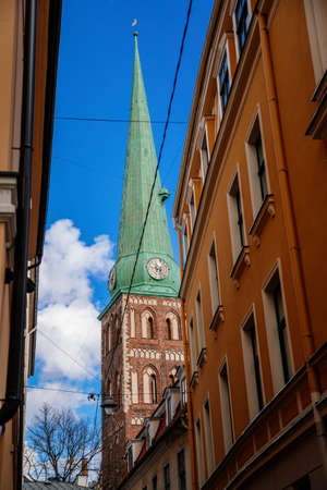 Riga, Latvia, 14 October 2021: Narrow picturesque street, Facade of colorful buildings in historic center of medieval city, renaissance and baroque houses at summer sunny day, cafe with wooden windowsのeditorial素材