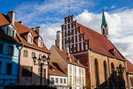 Riga, Latvia, 19 October 2021: John's Church, UNESCO heritage in Baltic states, Northern Gothic Style with Red brick and spire, recognizable medieval landmark at old town on sunny dayのeditorial素材