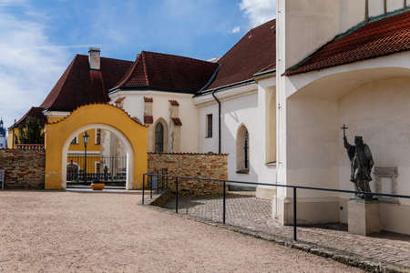 Litomysl, Czech Republic, 17 April 2022: gothic medieval church of the Exaltation of the Holy Cross with tower at sunny summer day, Chapel of St. Marquette, stone statuesのeditorial素材