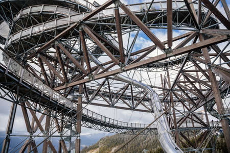Dolni Morava, Czech Republic, 16 April 2022: Path in the clouds, tourist attraction with spiral platform to observation tower, landscape with forest and sky on mountains, Skywalk with snowの写真素材