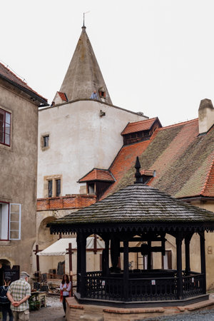 Krivoklat, Czech Republic, 21 August 2022: Courtyard of fortified medieval royal gothic castle, National cultural landmark in summer day, Fortress walls and tower, old wooden well with a roofのeditorial素材